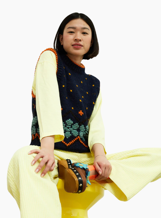 Chaleco Jumpy azul de Dr. Bloom con flores naranjas y detalles en contraste