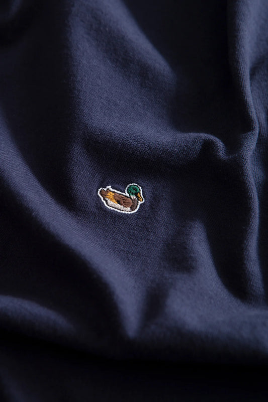 Detalle del icónico pato bordado en la camiseta azul marino Duck Patch de Edmmond Studios para hombre