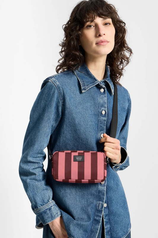 Mini bolso Wouf Sophie llevado cruzado, con estampado de rayas rosas y burdeos y formato compacto