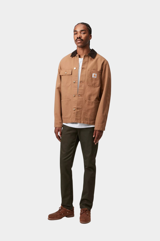 Pantalón Carhartt WIP Sid Cypress kaki puesto, con corte slim tapered y tejido de sarga elástica Lamar