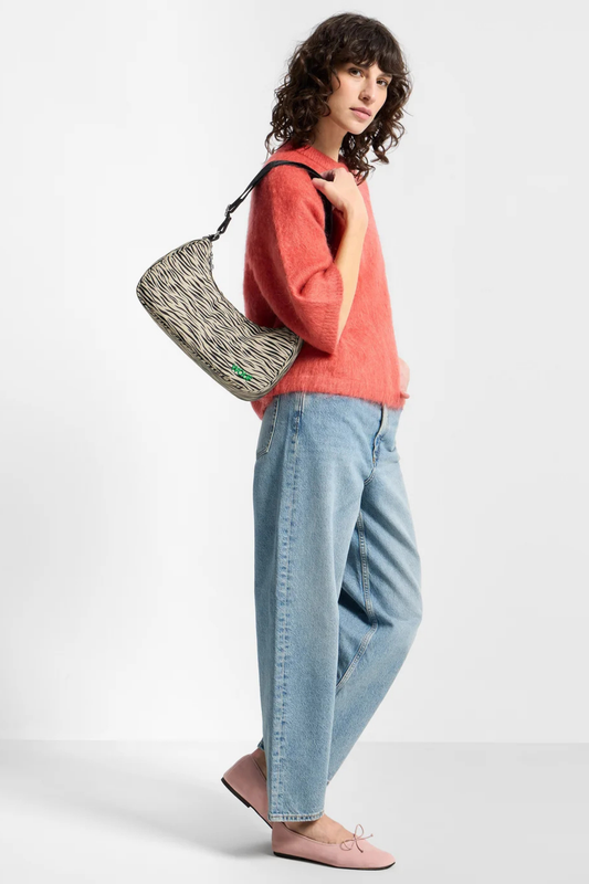 Bolso Wouf Zebra Hit llevado al hombro con estampado de cebra en beige y negro y silueta compacta