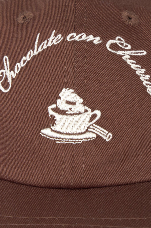 Detalle del bordado frontal de la gorra Churros Marrón Thinking Mu con ilustración de café y tipografía bordada