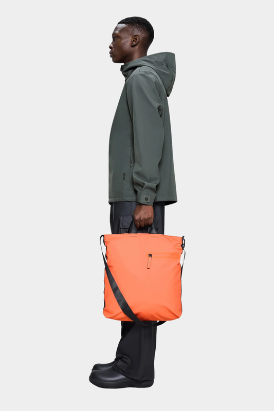 Bolso Rains Dash Tote color Ember llevado en la mano con diseño amplio, ligero e impermeable