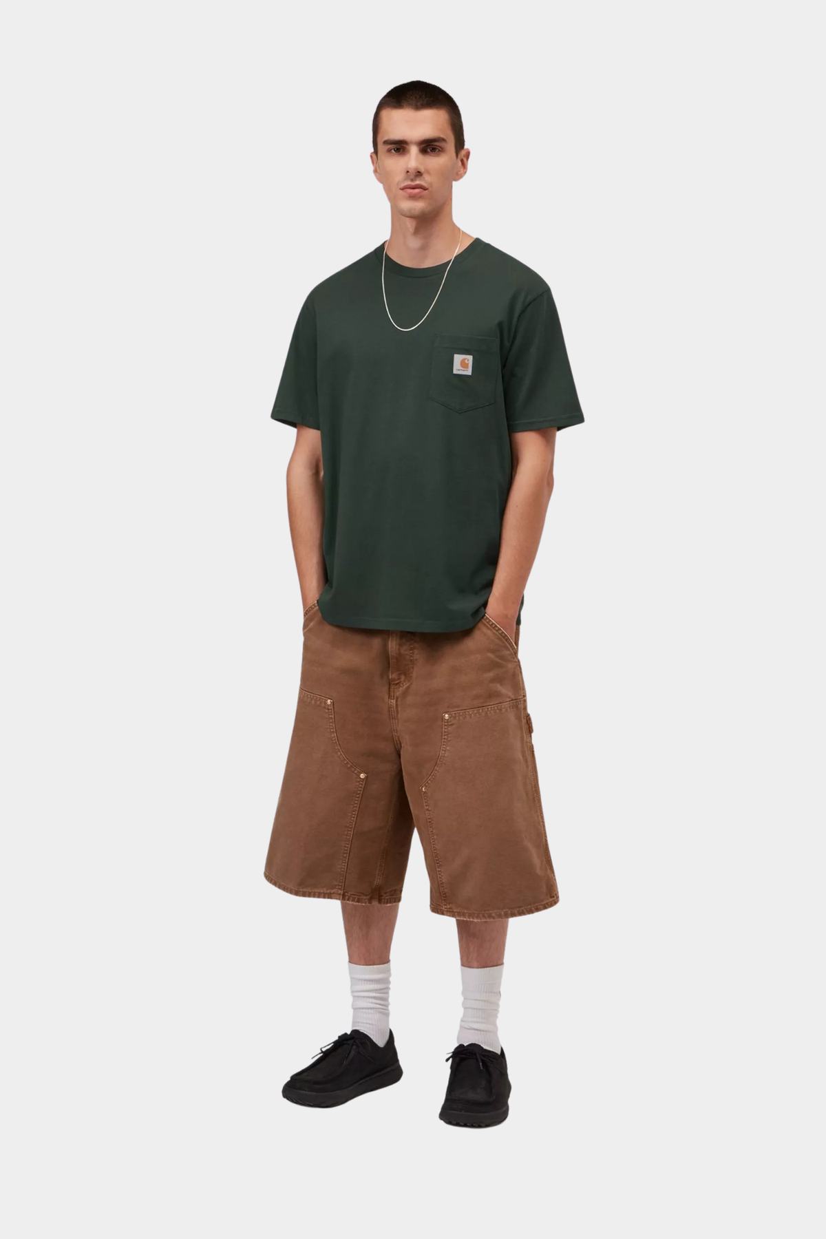 Look de hombre con camiseta Carhartt WIP S/S Pocket Dark Scarab en verde oscuro, con bolsillo frontal y etiqueta tejida