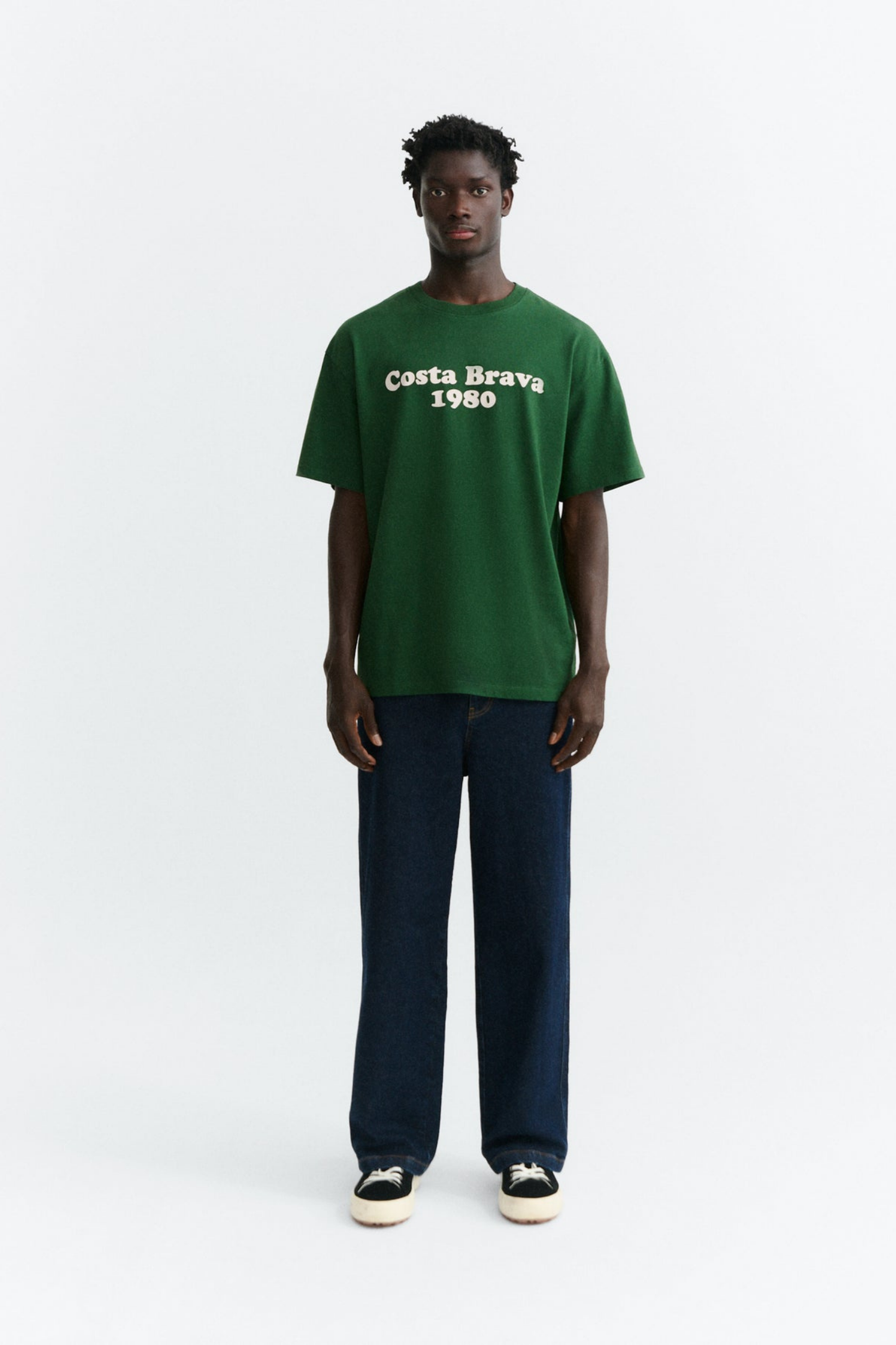 Look de hombre con camiseta verde Costa Brava Aaron de Thinking Mu de corte regular combinada con pantalón vaquero