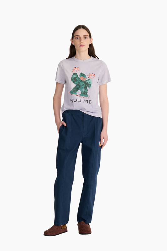 Look de mujer con camiseta cropped Hug Me de Bobo Choses en color lavanda combinada con pantalón azul marino