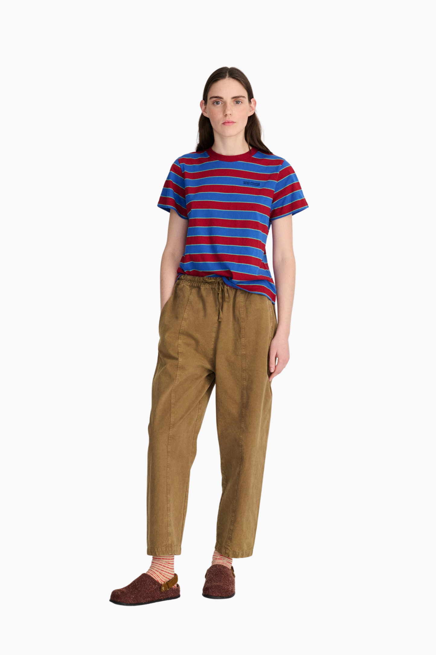 Look de mujer con camiseta cropped de rayas azules y rojas Bobo Choses combinada con pantalón marrón